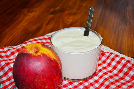 vanilla yogurt with peach pieces and fruit basketの写真素材