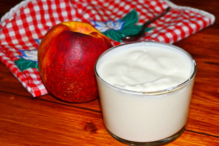 vanilla yogurt with peach pieces and fruit basketの写真素材