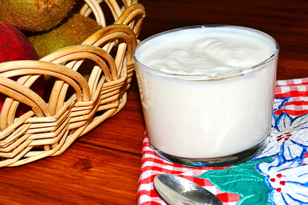 vanilla yogurt with peach pieces and fruit basketの写真素材