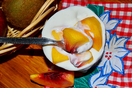 vanilla yogurt with peach pieces and fruit basketの写真素材