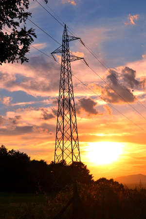 high voltage cables on cloudy sky at sunsetの写真素材