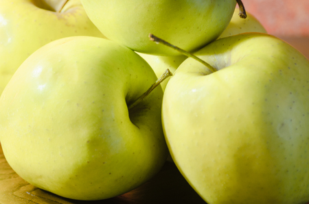 green apples on wooden table with incandescent lightingの写真素材
