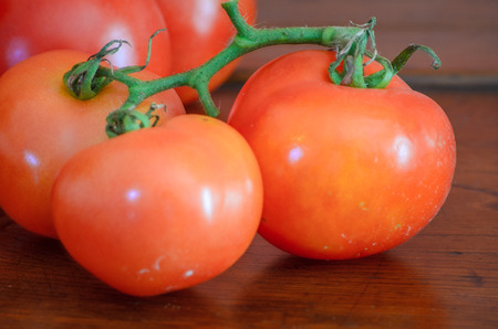 Cluster tomatoes on wooden table with natural lightingの写真素材