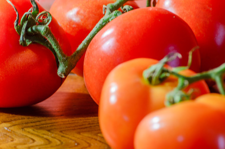 Cluster tomatoes on wooden table with natural lightingの写真素材