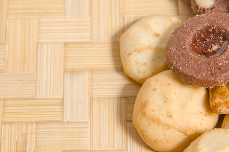 assorted pastries of various shapes and colors on intricate straw tray, with copy space.の写真素材