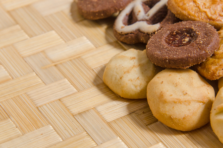 assorted pastries of various shapes and colors on intricate straw tray, with copy space.の写真素材