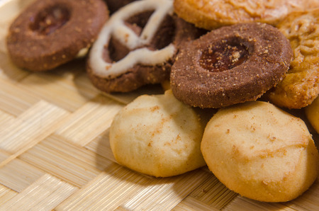 assorted pastries of various shapes and colors on intricate straw tray, with copy space.