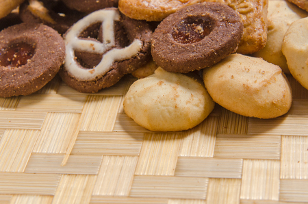 assorted pastries of various shapes and colors on intricate straw tray, with copy space.の写真素材