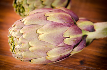 composition of raw artichokes on a brown wooden tableの写真素材