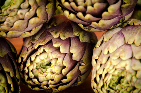 composition of raw artichokes on a brown wooden tableの写真素材
