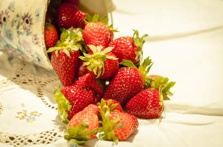 fresh strawberries on a bucket and white tableclothの写真素材