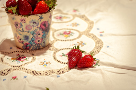 fresh strawberries on a bucket and white tableclothの写真素材