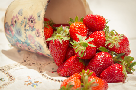 fresh strawberries on a bucket and white tableclothの写真素材