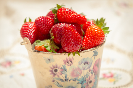 fresh strawberries on a bucket and white tableclothの写真素材