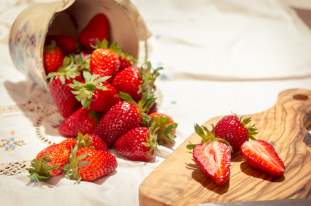 fresh strawberries cut on an olive wood cutting boardの写真素材