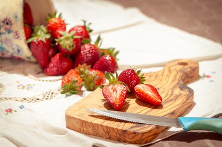 fresh strawberries cut on an olive wood cutting boardの写真素材
