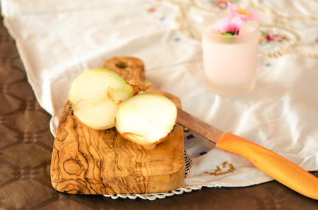 golden onion cut on olive wood cutting boardの写真素材