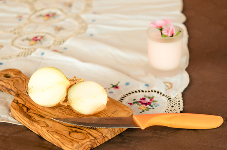 golden onion cut on olive wood cutting boardの写真素材