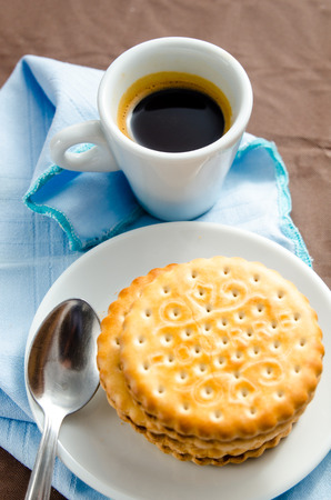 Italian breakfast with a cup of coffee and chocolate-filled biscuitsの写真素材
