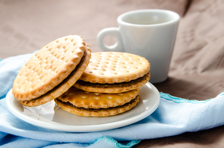 Italian breakfast with a cup of coffee and chocolate-filled biscuitsの写真素材