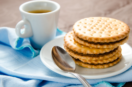 Italian breakfast with a cup of coffee and chocolate-filled biscuitsの写真素材