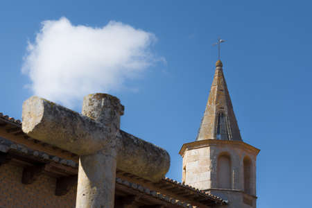 View of the tower of a monastery and a stone crossの写真素材
