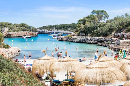 Landscape of sky, sea and people on the beach. Cala Sa Nau, Majorcaの写真素材