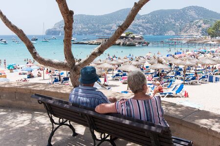 Two grandparents looking at a beach landscape in Camp de Mar, Majorcaの写真素材