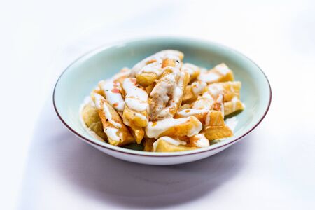 Potato dish with sauce on a white backgroundの写真素材