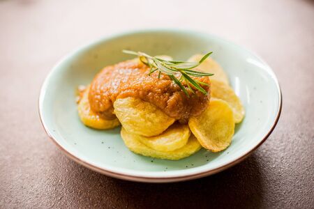 Potato dish with sauce on a white backgroundの写真素材
