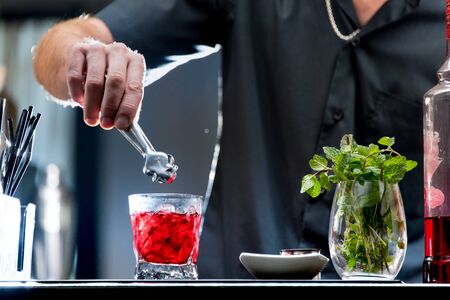 Bartender serving a red cocktailの写真素材