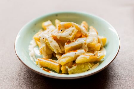 Potato dish with sauce on a white backgroundの写真素材
