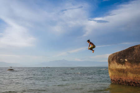 Jumping rocks and having fun at Ilha Grande, Rio do Janeiro, Brazil.の写真素材