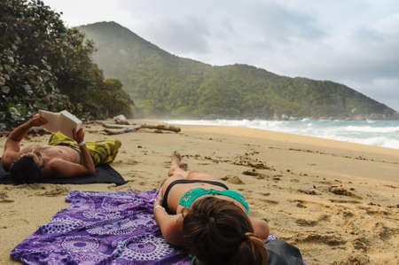 Couple Relaxing and reading at Tayrona Beach Colombia. South America. Latin American Cultureの写真素材