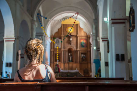 Religious scene young female praying at local church in Mexico.のeditorial素材
