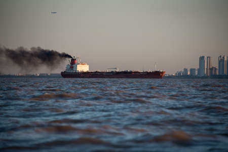 Cityscape South America. Cargo ship generating Pollution.