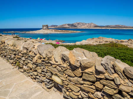 La Pelosa Beach in Stintino, Sardinia, Italy. In the background, the landmark 16th century La Pelosa Tower (Italian: Torre della Pelosa).の写真素材