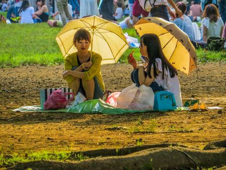 TOKYO, JAPAN - MAY 30, 2015: Japanese girls sitting in Yoyogi Park.のeditorial素材