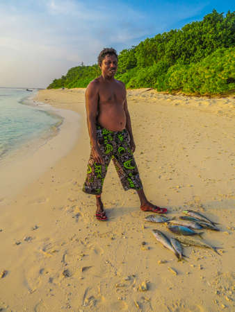 UKULHAS, MALDIVES - JANUARY 9, 2016: Maldivian fisherman posing for picture proud with his catches.のeditorial素材