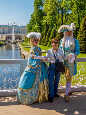 ST. PETERSBURG, RUSSIA - MAY 24, 2016: Tourist posing with couple wearing traditional Russian...
