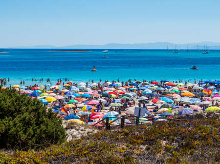 STINTINO, ITALY - JULY 20, 2016: Colored beach umbrellas on the crowded La Pelosa Beach in Stintino, Sardinia, Italy.のeditorial素材