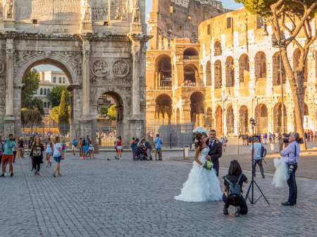 ROME, ITALY - AUGUST 24, 2016: Beautiful young Italian couple, just married, posing in front of the Colosseum.のeditorial素材