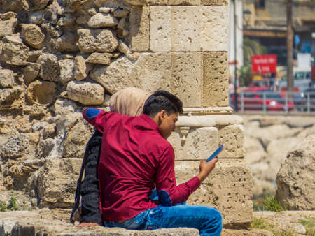 SIDON, LEBANON - MAY 21, 2017: Arabic couple sitting on the ruins of the Sidon Sea Castle.のeditorial素材