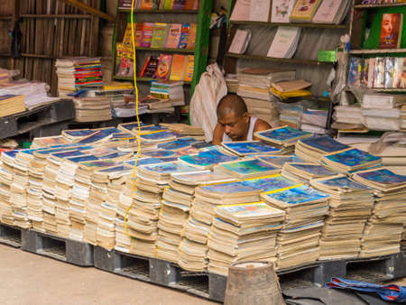 YANGON, MYANMAR - JANUARY 4, 2018: Man selling books on a street in the city center.のeditorial素材