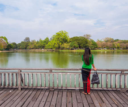 Yangon, Myanmar - January 4, 2018: Burmese girl looking at the Kandawgyi Lake.のeditorial素材