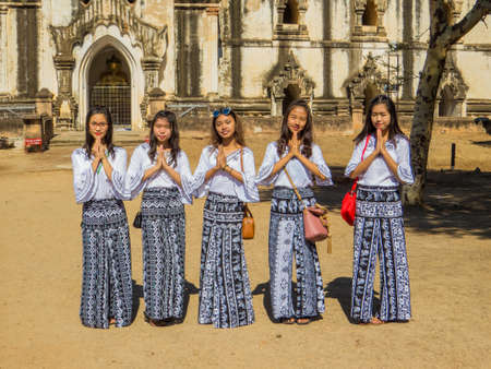 BAGAN, MYANMAR - JANUARY 6, 2018: Cute Burmese girls, wearing traditional dress, posing in front of the Thatbyinnyu Paya.のeditorial素材