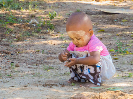 BAGAN, MYANMAR - JANUARY 6, 2018: Burmese baby playing near the temples in Old Bagan.のeditorial素材