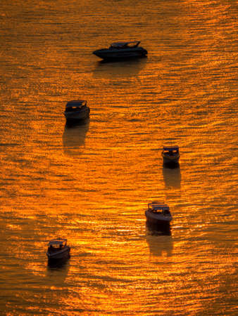 PATTAYA, THAILAND - FEBRUARY 1, 2018: Boats in the port at sunset on a magical golden sea.のeditorial素材