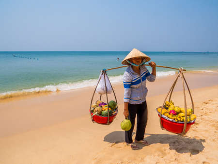 PHU QUOC, VIETNAM - FEBRUARY 6, 2018: Vietnamese woman selling fruit on the popular Long Beach.のeditorial素材