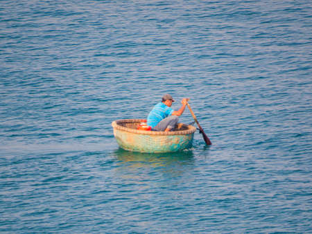 PHU QUOC, VIETNAM - FEBRUARY 7, 2018: Local fisherman on the traditional "thungchay" (basket boat) at sunrise.のeditorial素材